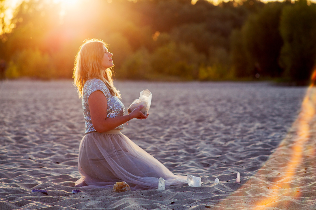 Beautiful woman on beach holding healing crystals